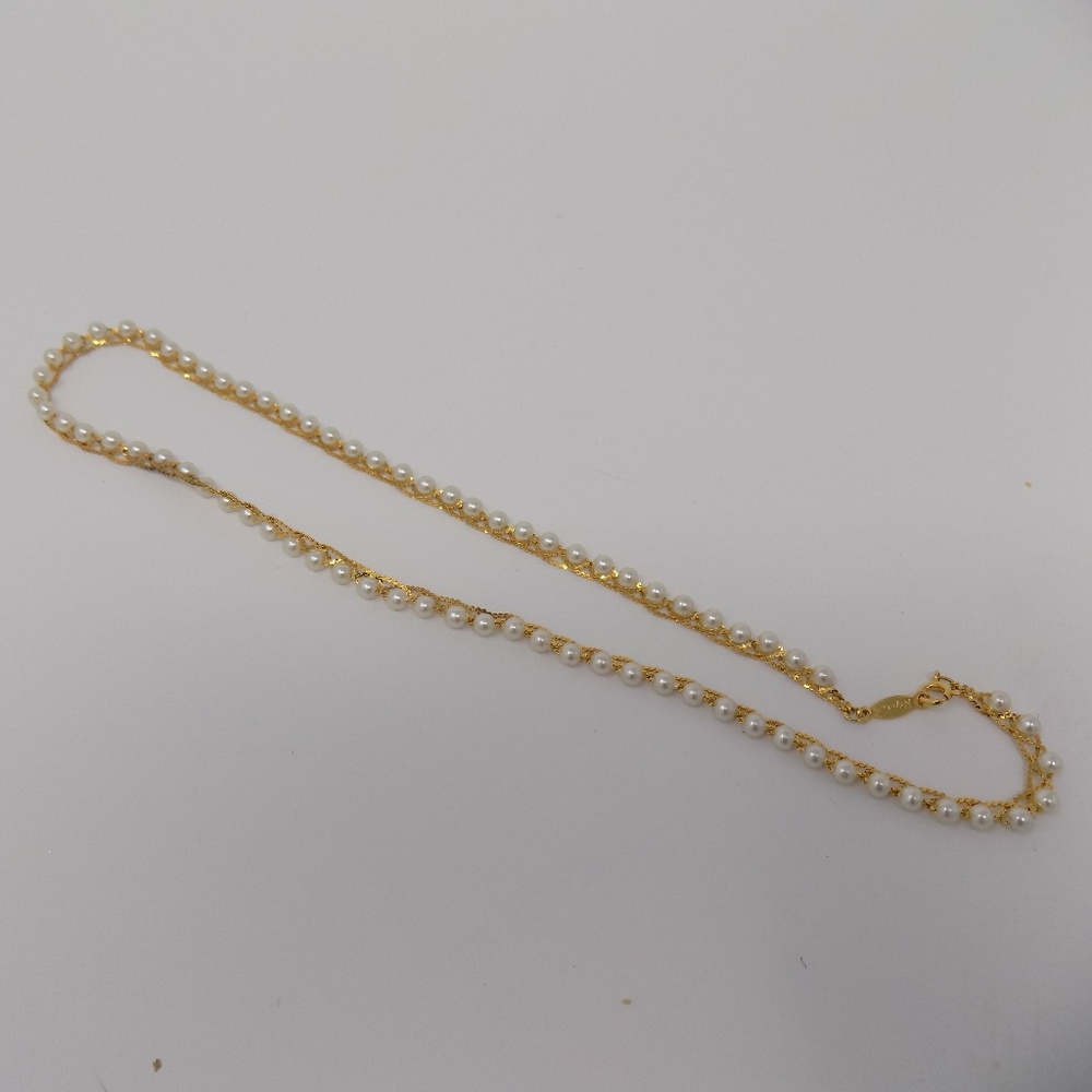 Gold chain wrapped around faux white pearls